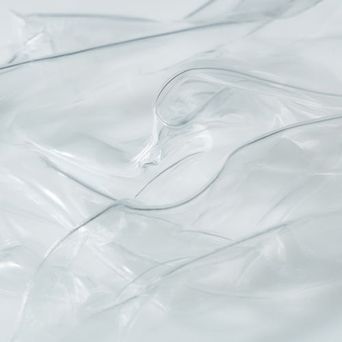 Close-up of transparent hydrogel mask sheets layered to highlight their smooth, ultra-thin texture