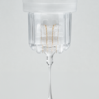 Close-up of the Roller Gold device dispensing a clear serum through its gold-plated micro-needle roller head